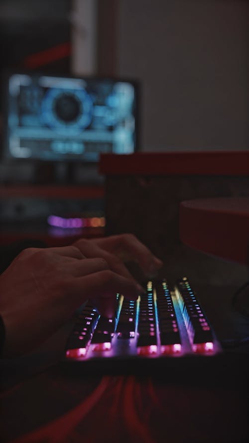 Hands Typing on Backlit Keyboard Close up