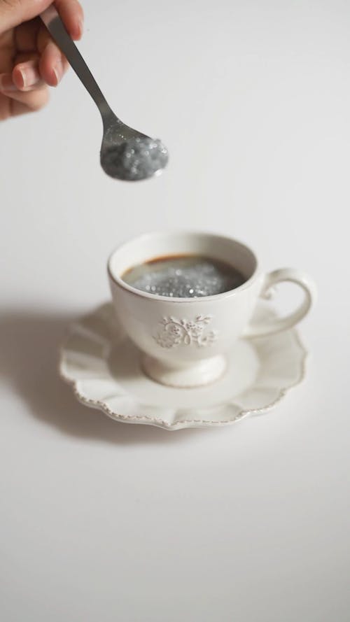 Person Pouring a Scoop of Silver Glitters