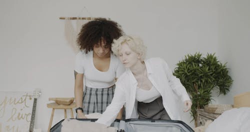 Two Women Packing A Luggage
