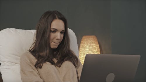 Woman using Laptop on Bed