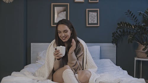 A Woman Keeping Warm By Having A Hot Cup Of Drink