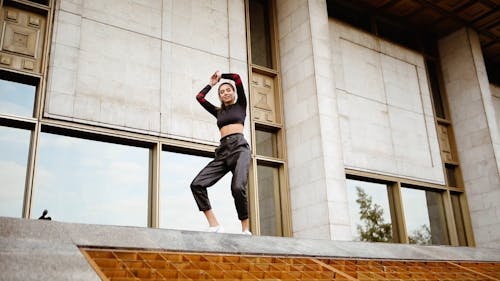 A Young Woman Dancing Outside Of A Building