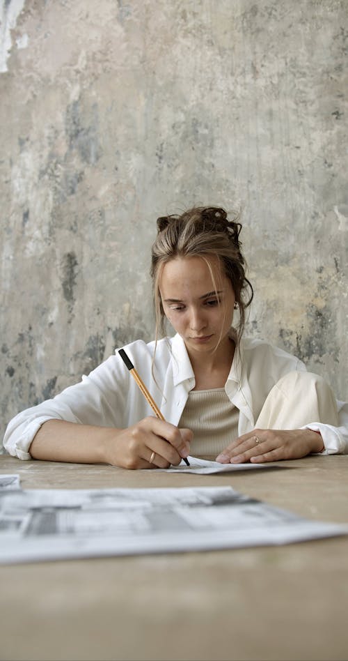 A Woman Drawing Sketches On A Piece Of Paper