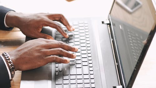 A Person Typing on a Laptop