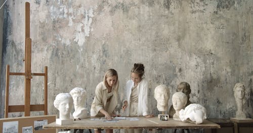 Women Discussing while Looking at the Papers on the Table