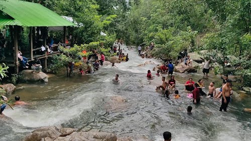 People Bathing in Rain Forest River