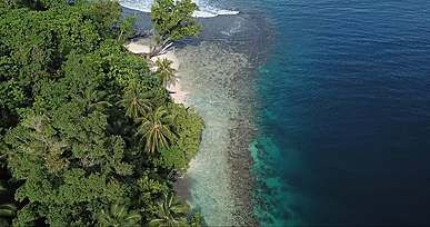 drone footage of an island and blue waters