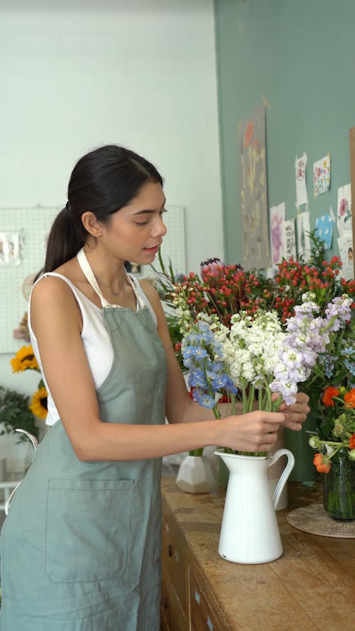 Woman Arranging Flowers in Vase at Her Florist Shop