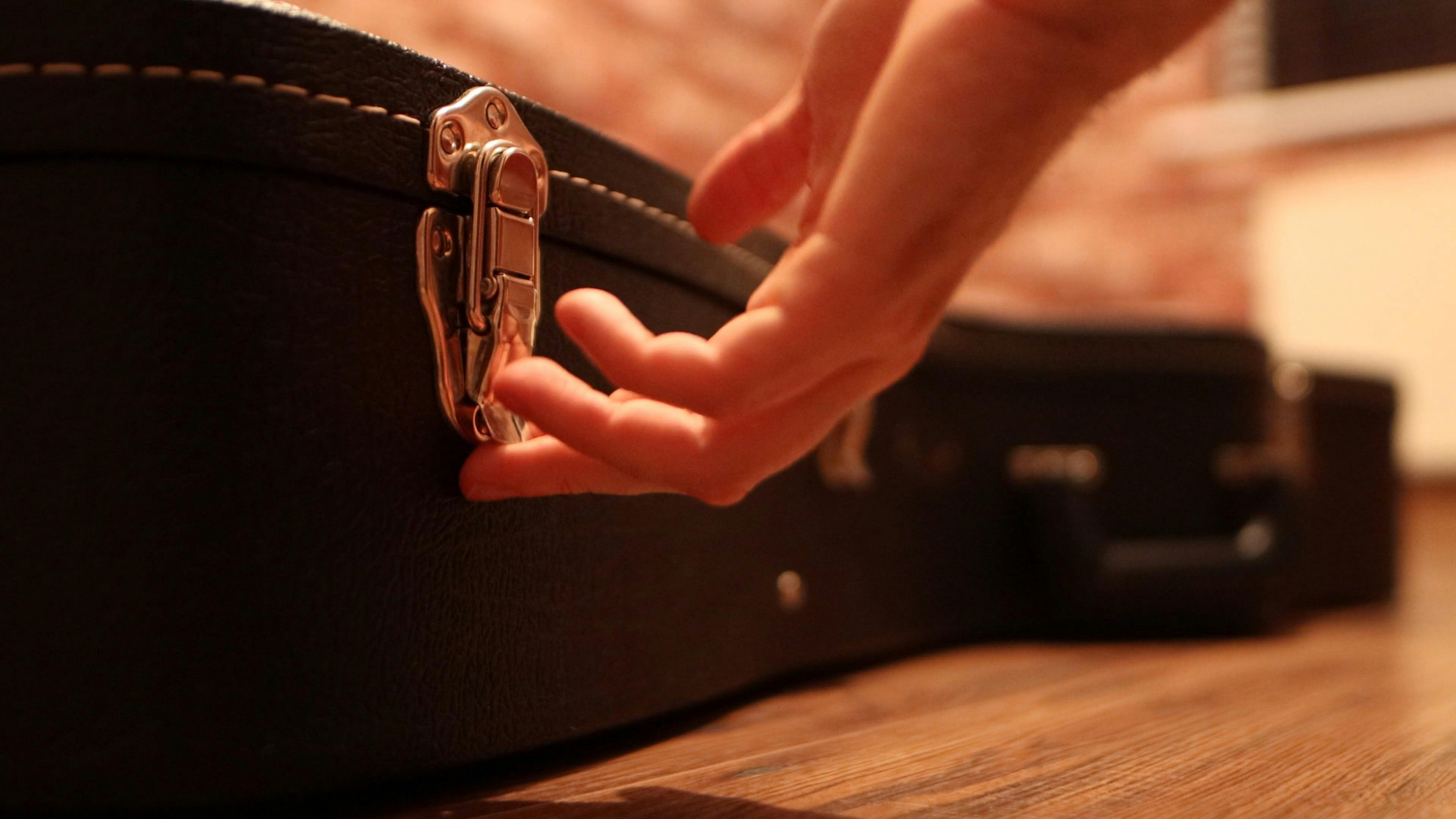 Person Opening a Guitar Case · Free Stock Video