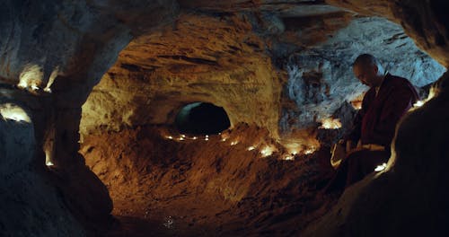 A Monk Reading Buddhist Text Inside a Cave