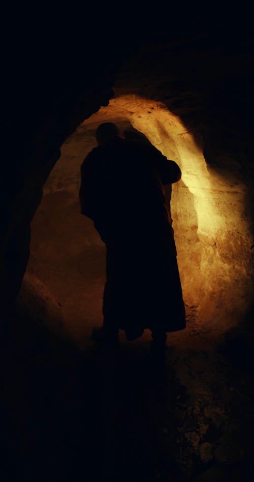 A Person Holding a Lantern Inside a Dark Tunnel