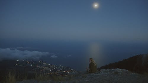 A Woman on Top of a Mountain Overlooking the City