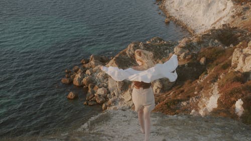 A Woman Standing on a Cliff Edge