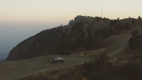 An Aerial Footage of a Car Moving on an Unpaved Road