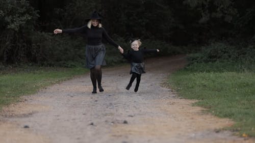 Mother and Daughter Running While Wearing Halloween Costumes