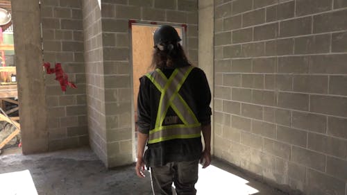 A Construction Worker Walking Inside a Building