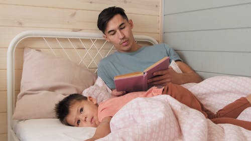 Father Reading a Bed Time Story to His Son