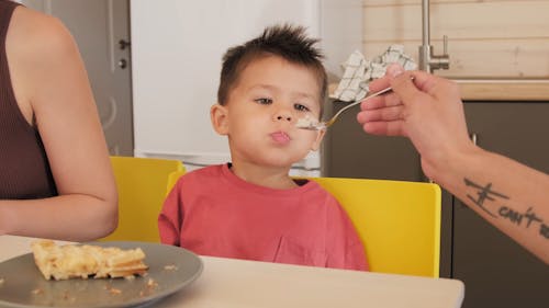 Father Feeding Child During Breakfast