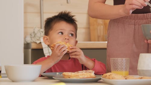 Little Boy Eating Breakfast with Parents