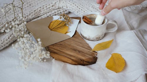 Person Putting a Marshmallows on the Coffee