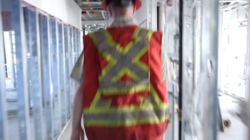 Back View of Workers Walking in Construction Site