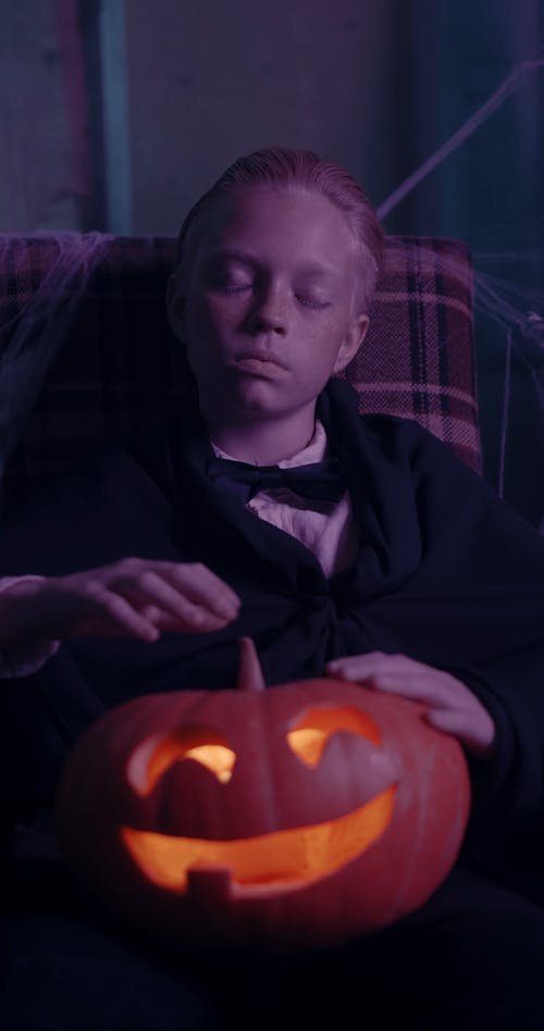 Young Boy Holding a Curved Pumpkin