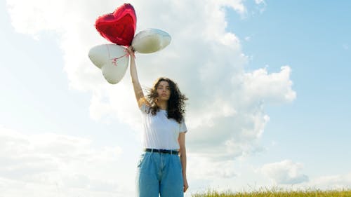 Woman Holding a Heart Shaped Balloons on the Outdoors