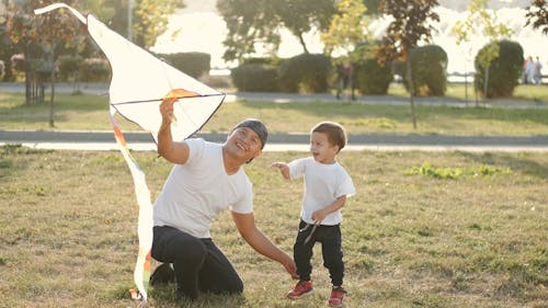 Young Father and Son Playing with the Kite