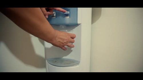 A Person Getting Water from the Water Dispenser