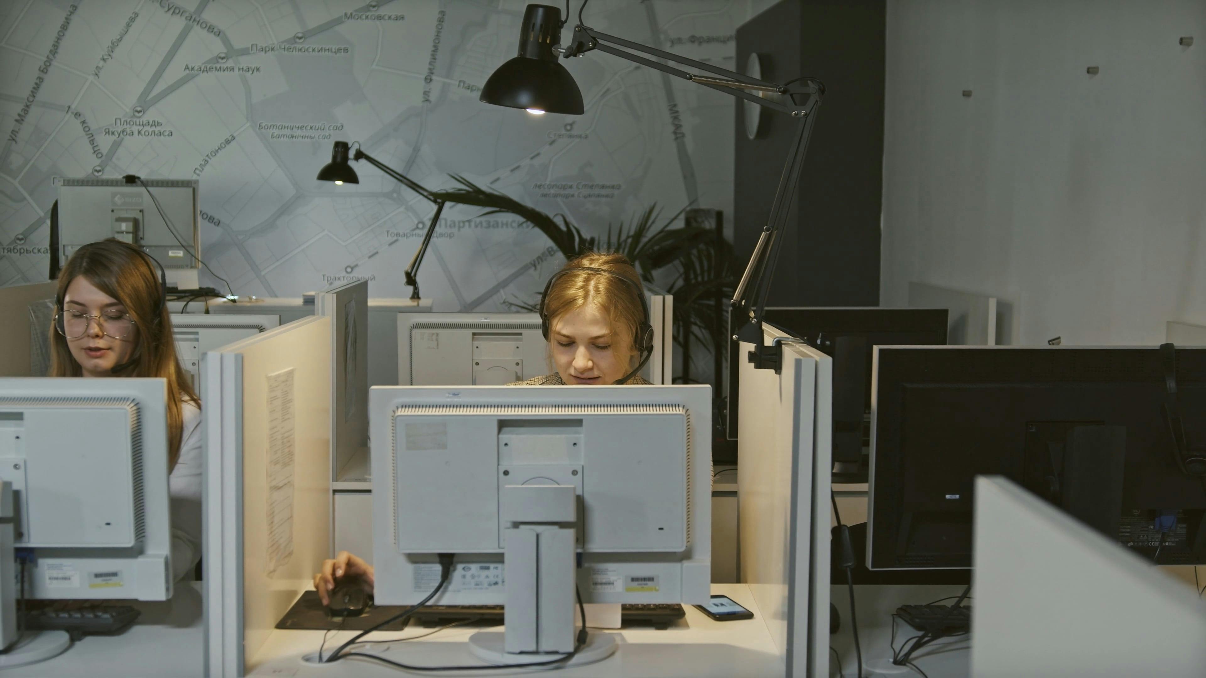 Two Female Customer Service Employees in Their Cubicles Free Stock ...