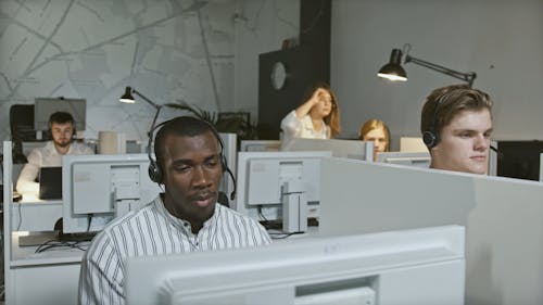 A Customer Service Guy Talking to his Friend While on Call with Customer