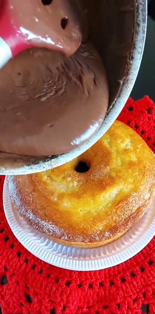 Person Pouring a Chocolate on the Cake