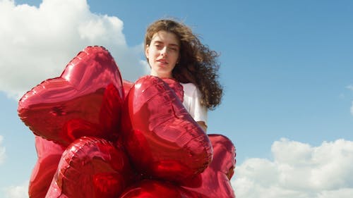 Beautiful Woman with Red Heart Shaped Balloons