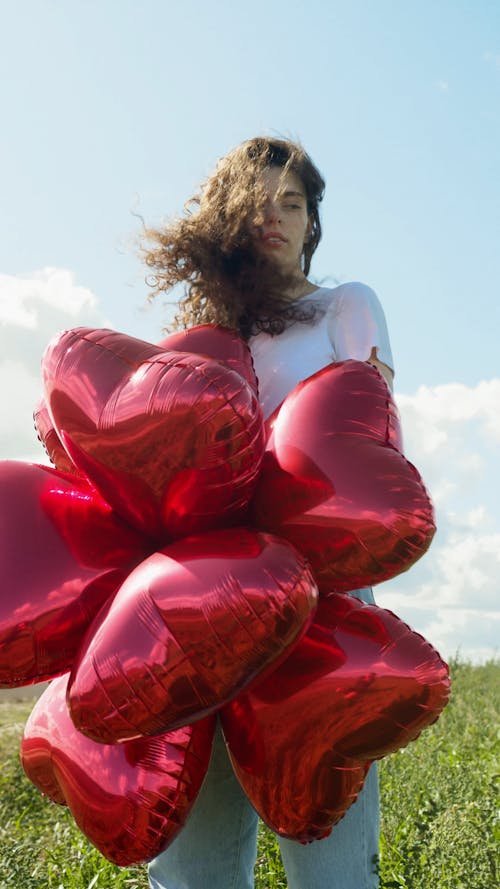 Woman Holding a Heart Shaped Balloons on the Outdoors