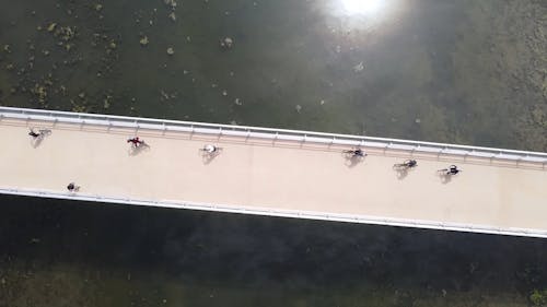 Top View of People Walking and Cycling over Bridge