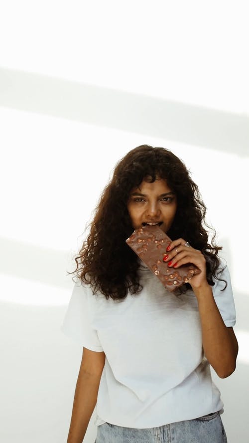 Young Woman Eating Chocolate Bar