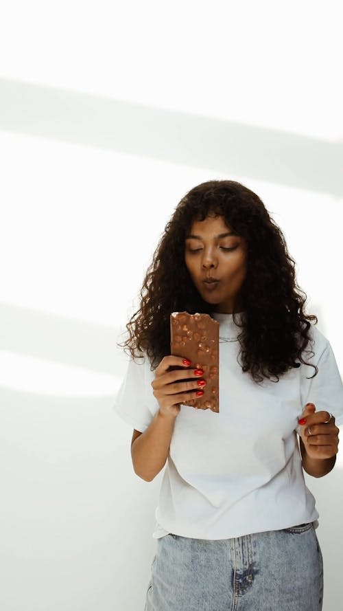 Young Woman Eating Chocolate Bar