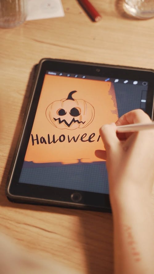 Female Hand Drawing Halloween Pumpkin on Digital Tablet