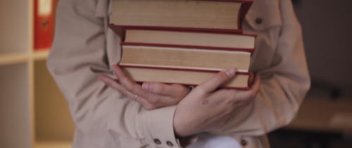 Woman Holding a Pile of Books