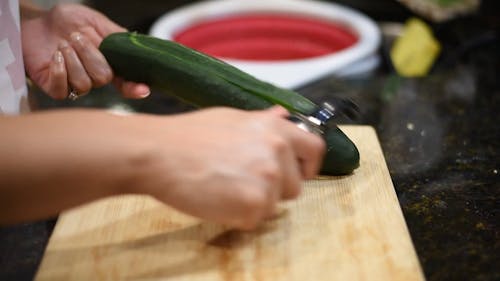 A Person Peeling a Cucumber