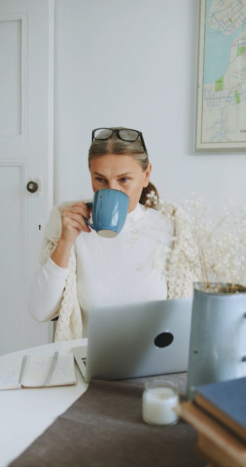 A Woman Drinking Coffee While Working