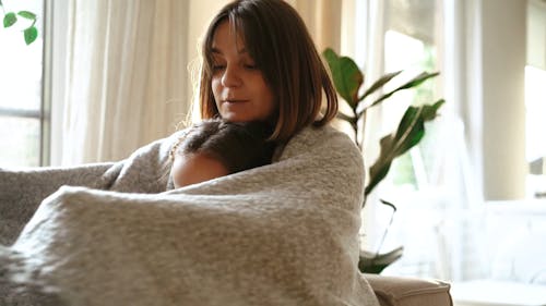 Mother and Daughter Hugging Under One Blanket