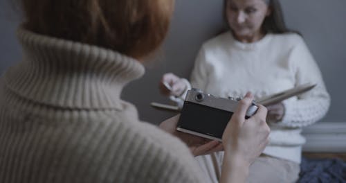 A Daughter Taking Her Mom's Photo With An Analog Camera