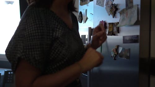 Woman Getting Water Bottle From Refrigerator