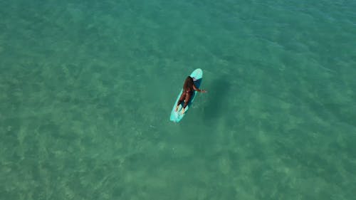 A Woman Surfing on Sea