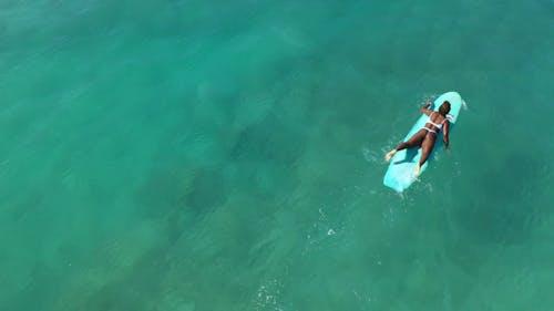Top View of Female Surfer Lying on Surfboard