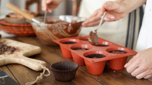 Filling A Cupcakes Tray With Chocolate Batter