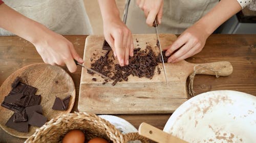 People Cutting Chocolate Bars Into Pieces