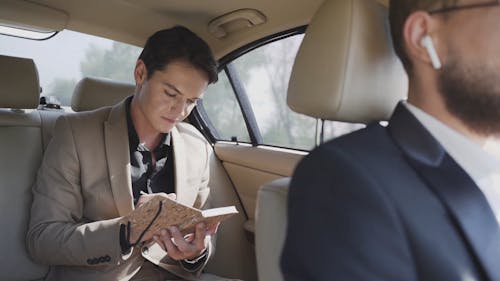 A Man Writing In His Planner