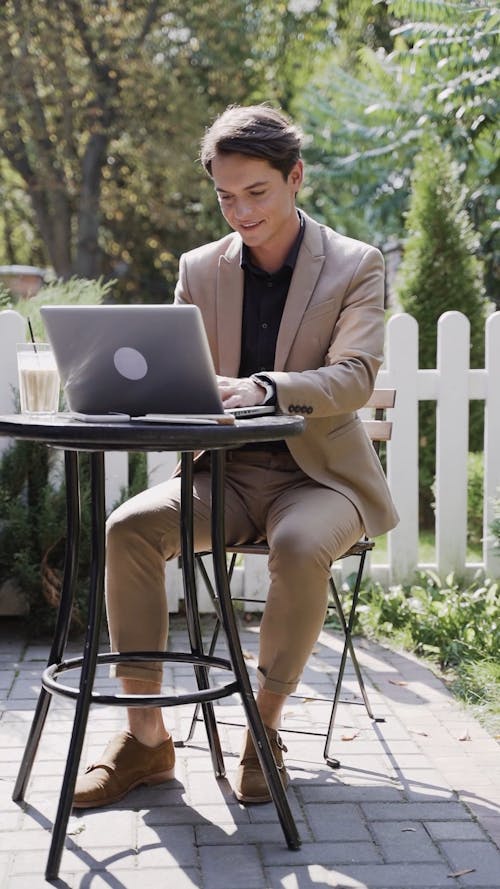 A Businessman Using A Laptop Outdoors